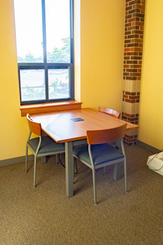 Friends of the Library Study Room with table and chairs next to a narrow window