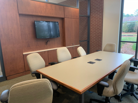 Small Room with conference table chairs and a mounted television