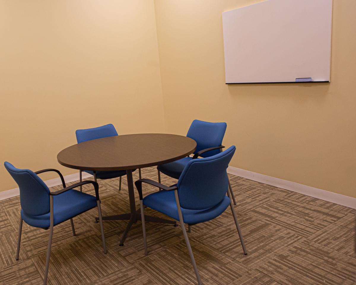 Room C with circular table, four chairs and whiteboard